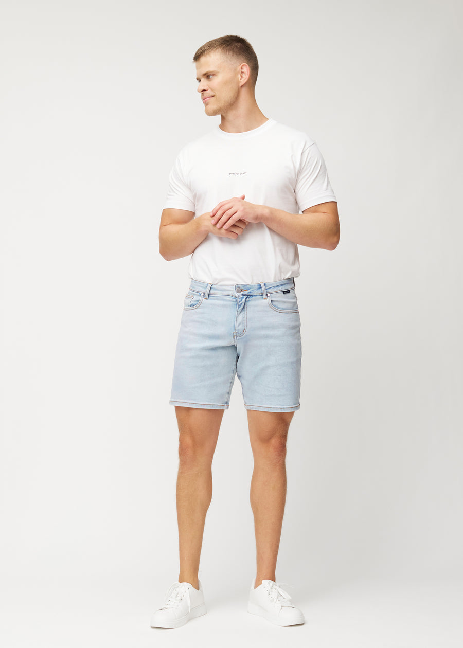 Fullt bilde av modell i lyseblå denimshorts til menn i fargen Waves med regular passform.