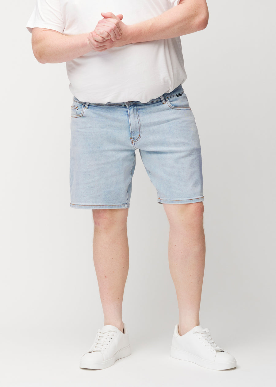 Lyseblå denimshorts til menn i fargen Waves med regular passform sett forfra på plus-size-modell, som sitter naturlig ved hoften og gir luft rundt lårene.