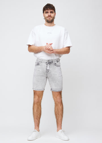 Fullt bilde av modell i lysgrå denim middle-slim shorts.