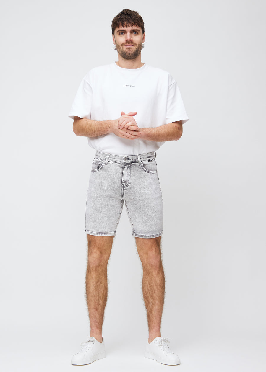 Fullt bilde av modell i lysgrå denim middle-slim shorts.