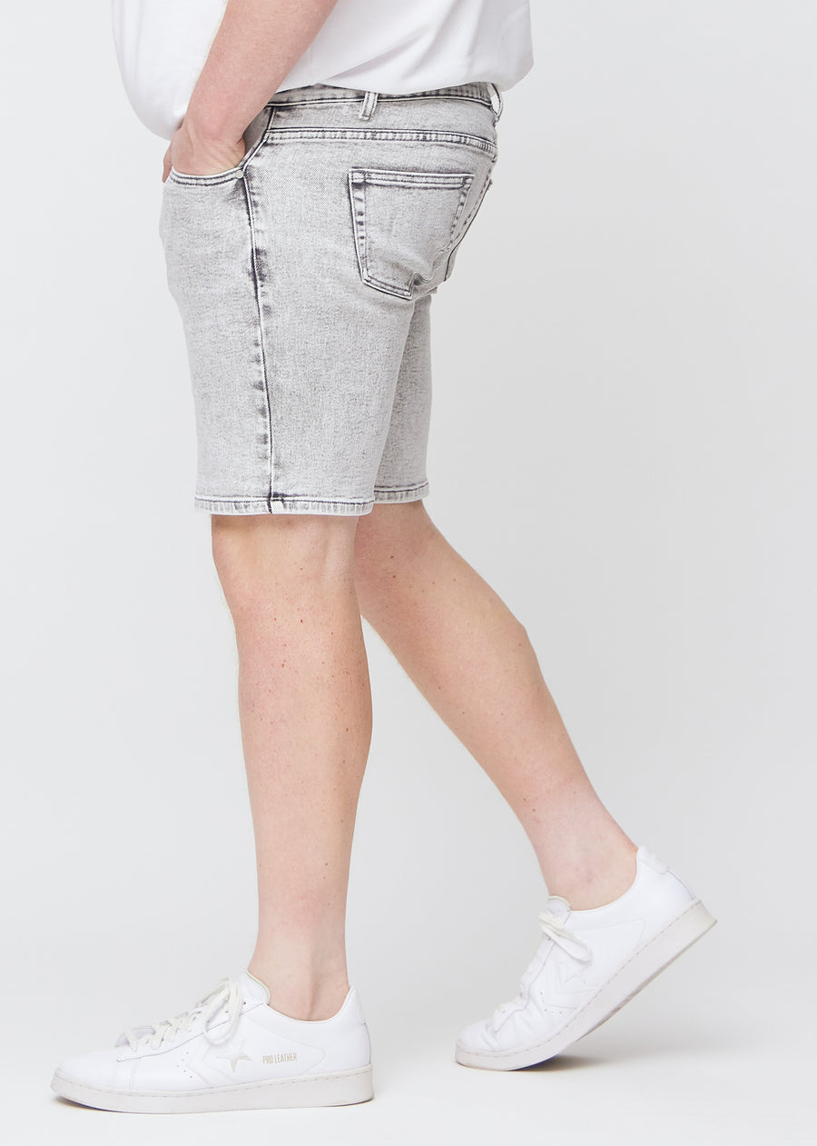 Lysgrå denim middle-slim shorts sett fra siden på en plus-size modell.