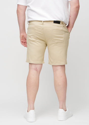 Beige middle-slim shorts sett bakfra på en plus-size-modell, slik at man kan se hele produktet.