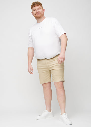 Fullt bilde av en plus-size-modell i beige middle-slim shorts.