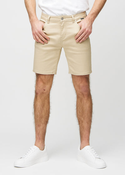 Beige middle-slim shorts, som sitter rett langs låret og slutter rett over kneet, sett forfra.