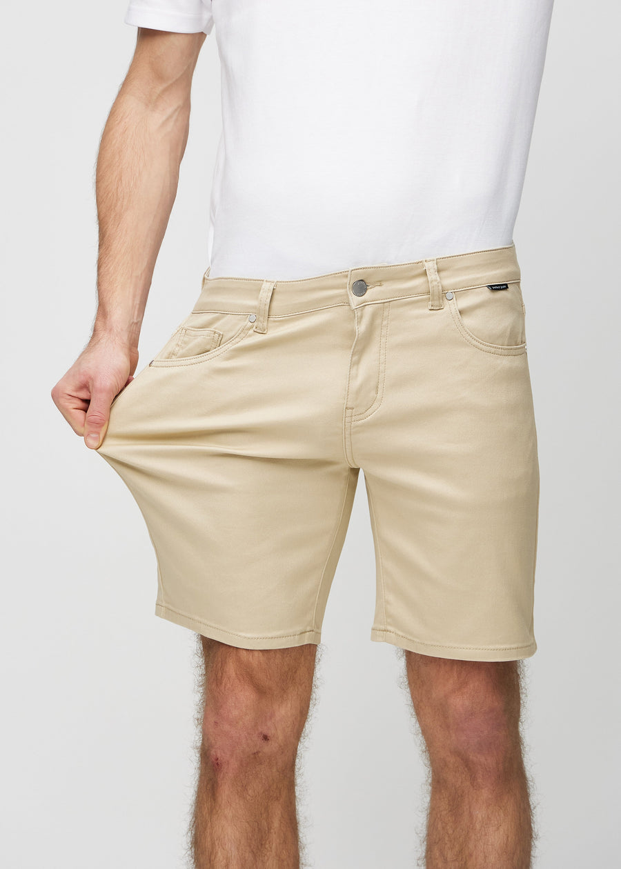 Modellen strekker shortsen ved låret for å vise stretch.
