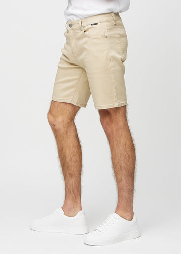 Beige middle-slim shorts sett fra siden på modell.