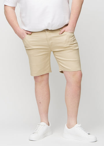 Beige middle-slim shorts, som sitter rett langs låret og slutter rett over kneet på en plus-size-modell, sett forfra.