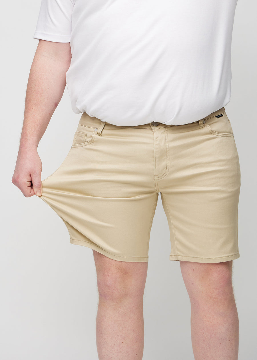 Plus-size-modellen strekker shortsen ved låret for å vise stretch.