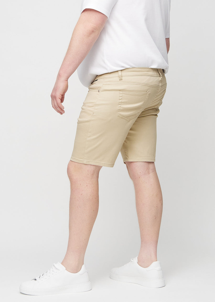 Beige middle-slim shorts sett fra siden på en plus-size-modell.