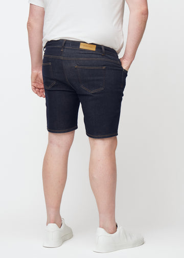 Dyp mørkeblå denimshorts til herre i fargen Midnights sett bakfra på plus-size modell.