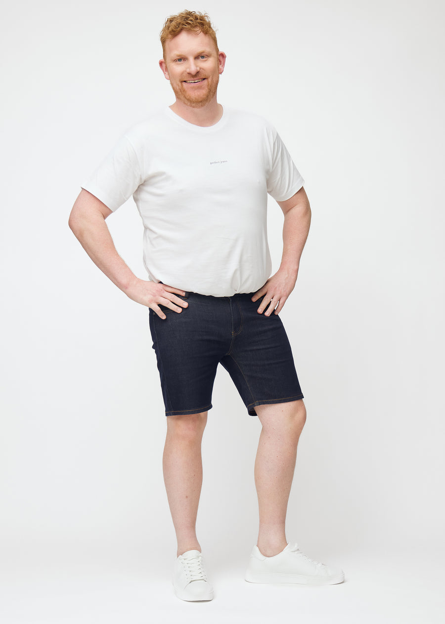 Helbilde av plus-size modell i dyp mørkeblå denimshorts til herre i fargen Midnights med slim passform.
