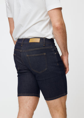Dyp mørkeblå denimshorts til herre i fargen Midnights sett bakfra i nærbilde for å vise passform og detaljer.
