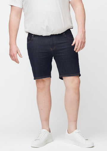 Dyp mørkeblå denimshorts til herre i fargen Midnights med slim passform sett forfra på plus-size modell.