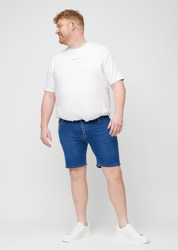 Fullt bilde av en plus-size-modell i mørke denim middle-slim shorts.