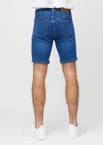 Mørke denim middle-slim shorts sett bakfra, så man kan se hele produktet.