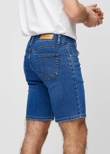 Mørke denim middle-slim shorts sett bakfra på nært hold for å vise detaljer.