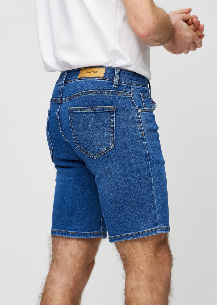 Mørke denim middle-slim shorts sett bakfra på nært hold for å vise detaljer.