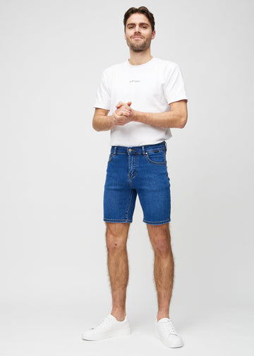 Fullt bilde av modell i mørke denim middle-slim shorts.