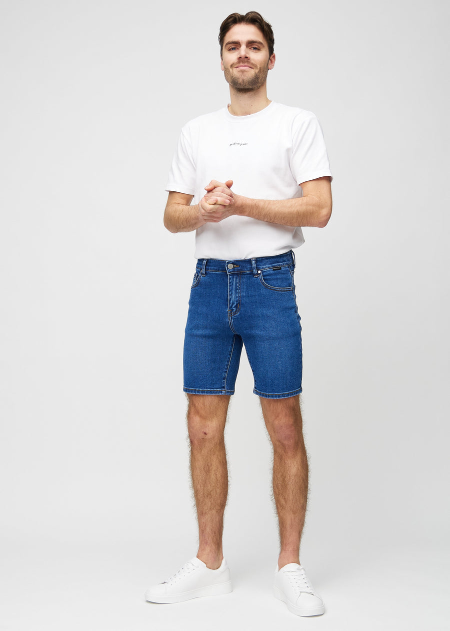 Fullt bilde av modell i mørke denim middle-slim shorts.