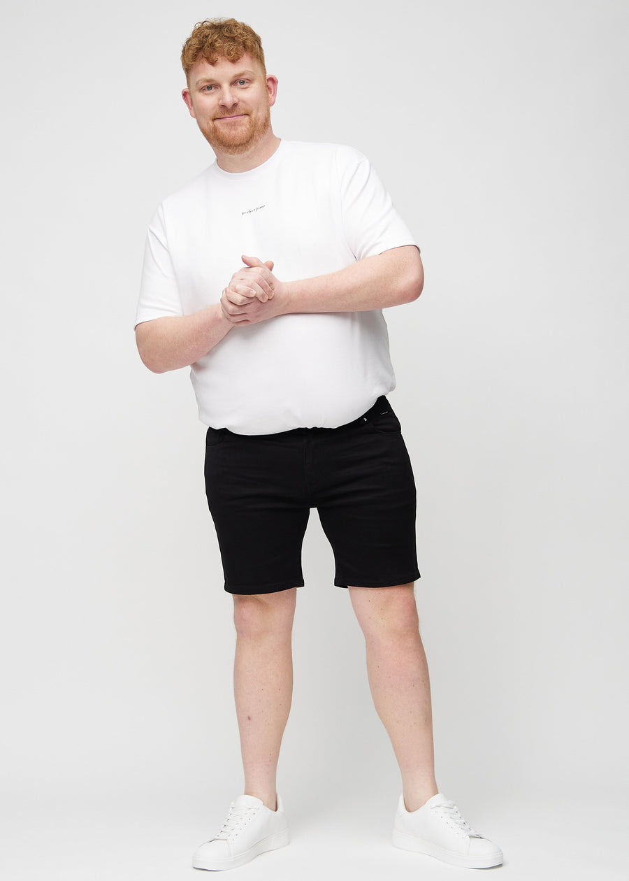 Fullt bilde av en plus-size-modell i svarte middle-slim shorts.