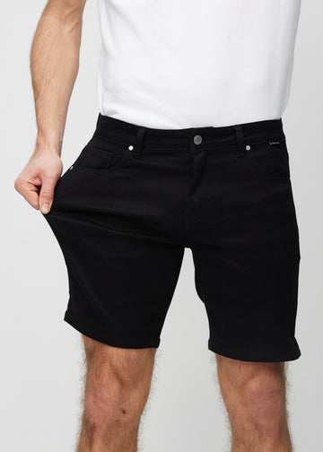 Modellen strekker shortsen ved låret for å vise stretch.
