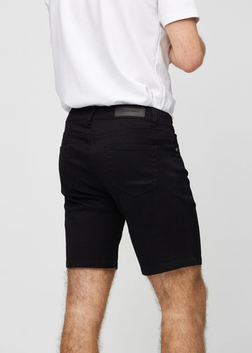 Svarte middle-slim shorts sett bakfra på nært hold for å vise detaljer.