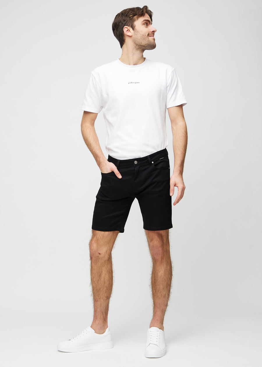 Fullt bilde av modell i svarte middle-slim shorts.