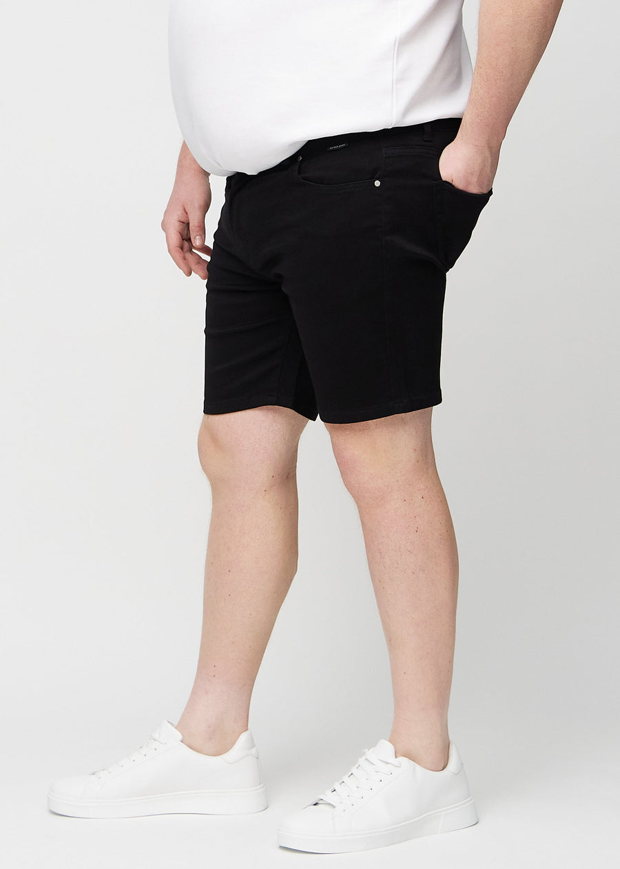 Svarte middle-slim shorts sett fra siden på en plus-size-modell.