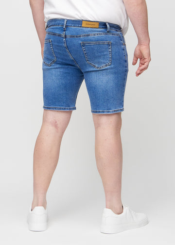 Denim middle-slim shorts sett bakfra på en plus-size-modell, slik at man kan se hele produktet.