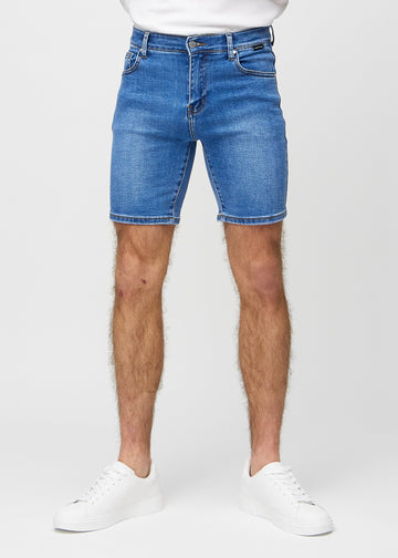 Denim middle-slim shorts, som sitter rett langs låret og slutter rett over kneet, sett forfra.