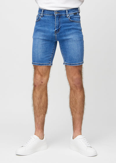 Denim middle-slim shorts, som sitter rett langs låret og slutter rett over kneet, sett forfra.