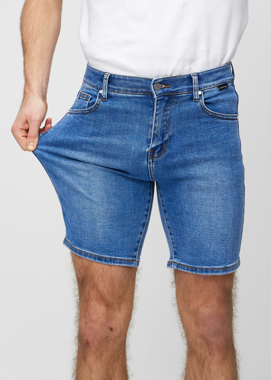 Modellen strekker shortsene ved låret for å vise stretch.