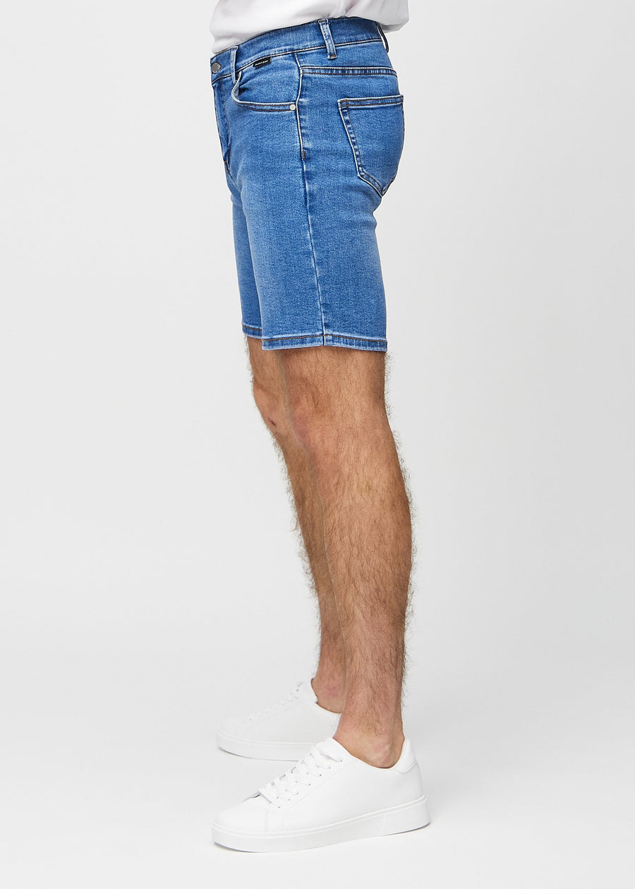 Denim middle-slim shorts sett fra siden på modell.