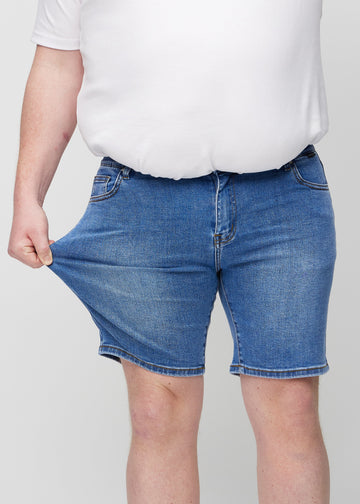 Plus-size-modellen strekker shortsene ved låret for å vise stretch.