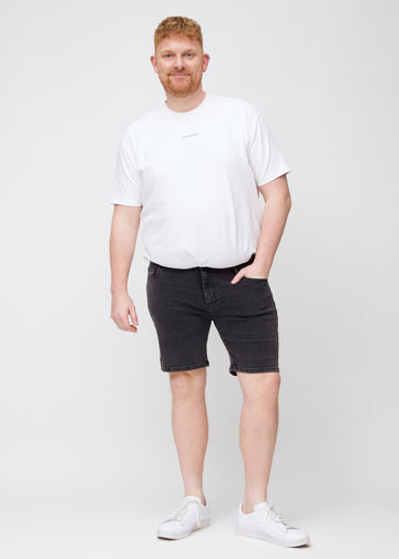 Fullt bilde av en plus-size-modell i mørkegrå denim middle-slim shorts.