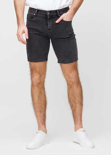Mørkegrå denim middle-slim shorts, som sitter rett langs låret og slutter rett over kneet, sett forfra.