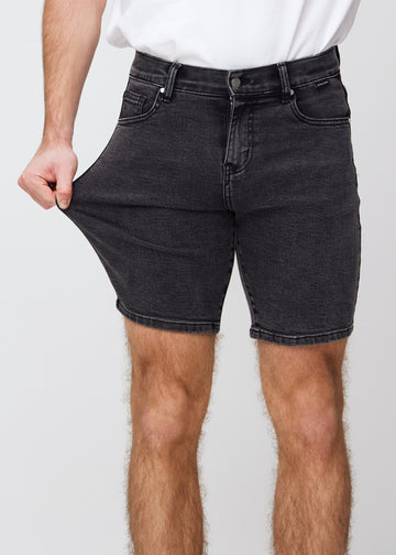 Modellen strekker shortsen ved låret for å vise stretch.