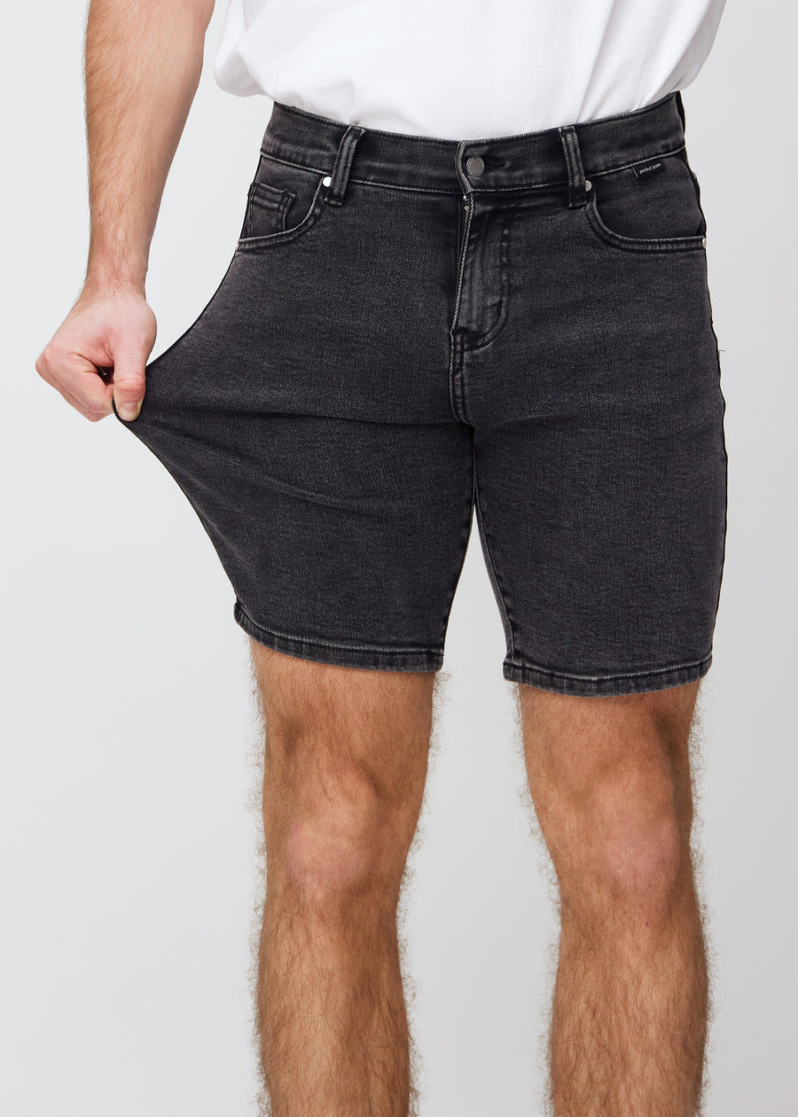Modellen strekker shortsen ved låret for å vise stretch.