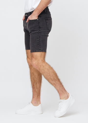Mørkegrå denim middle-slim shorts sett fra siden på modell.