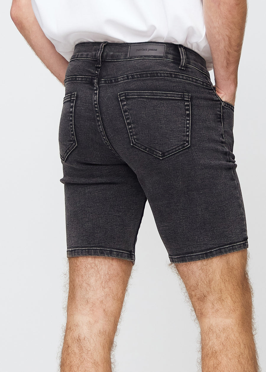 Mørkegrå denim middle-slim shorts sett bakfra på nært hold for å vise detaljer.