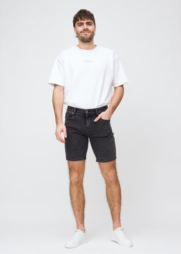 Fullt bilde av modell i mørkegrå denim middle-slim shorts.