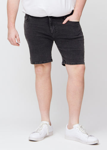 Mørkegrå denim middle-slim shorts, som sitter rett langs låret og slutter rett over kneet på en plus-size-modell, sett forfra.