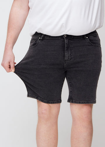 Plus-size-modellen strekker shortsen ved låret for å vise stretch.
