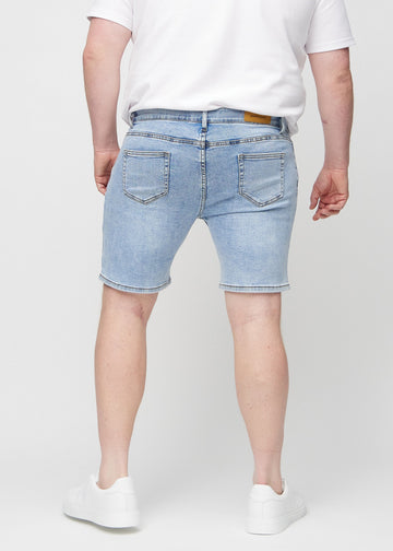 Lys denim middle-slim shorts sett bakfra på en plus-size-modell, så man kan se hele produktet.