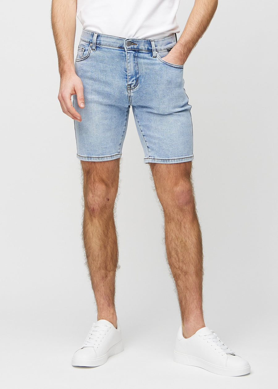 Lys denim middle-slim shorts, som sitter rett langs låret og slutter rett over kneet, sett forfra.