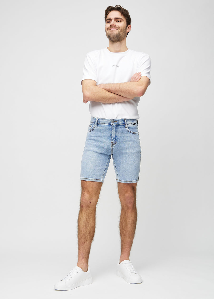 Fullt bilde av modell i lys denim middle-slim shorts.