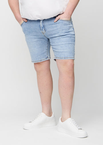 Lys denim middle-slim shorts, som sitter rett langs låret og slutter rett over kneet på en plus-size-modell, sett forfra.