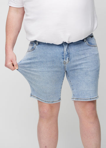 Plus-size-modellen strekker shortsen ved låret for å vise stretch.