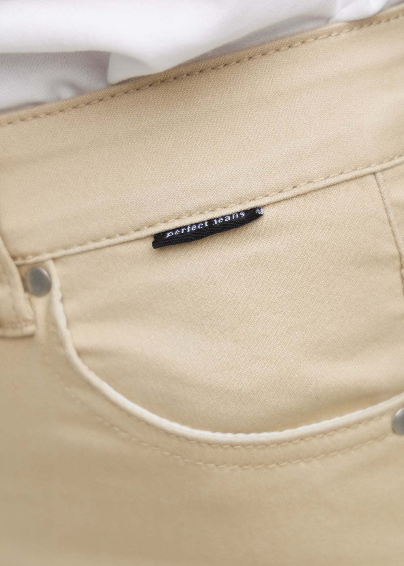 Forlommen på et par beige loose jeans, hvor man kan se logoet.