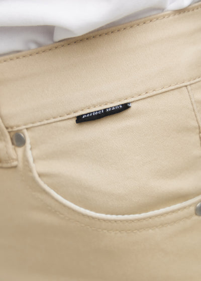 Forlommen på et par beige loose jeans, hvor man kan se logoet.